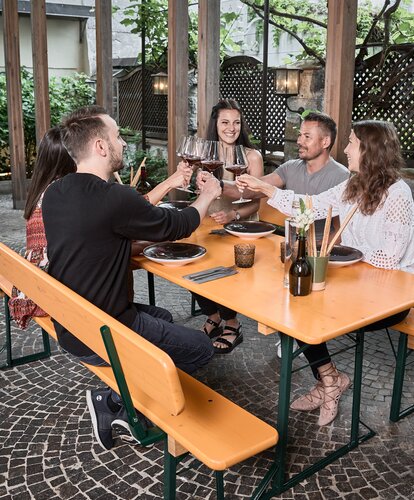 Mehrere Personen sitzen an einer Bierzeltgarnitur und essen.