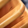 Mehrere Holzplatten in Kiefer sind übereinandergestapelt.