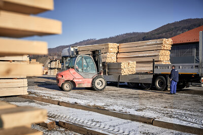Das Bild zeigt einen Stapler, der Holzlatten für die Bierzeltgarnituren auf einen LKW lädt.