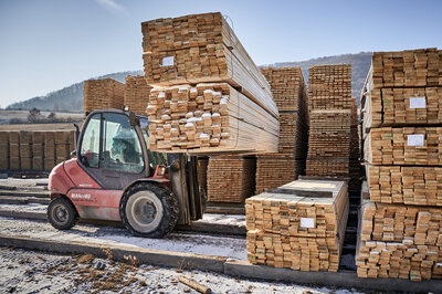 The forklift is moving the wooden panels from one place to another.