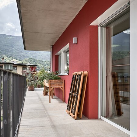 On a balcony, the small beer garden table set Shorty is folded and placed against the wall.
