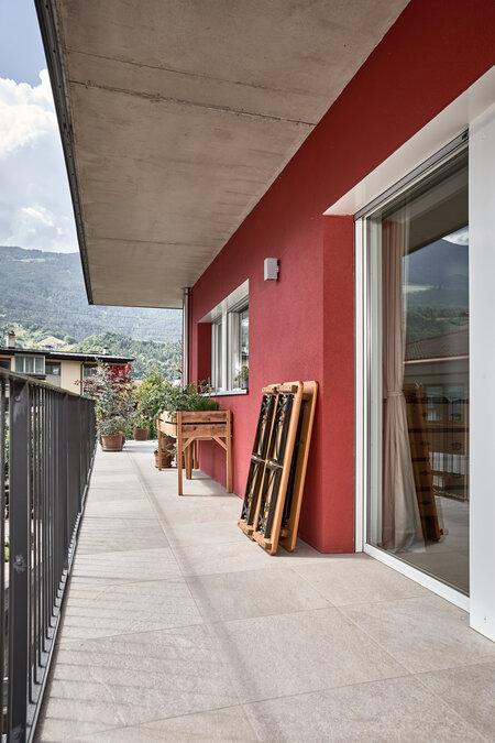On a balcony, the small beer garden table set Shorty is folded and placed against the wall.