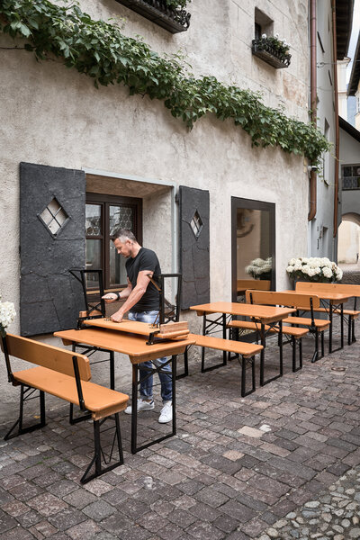 Ein Mann baut die kleine Bierzeltgarnitur "Shorty" ab, um sie zu lagern.