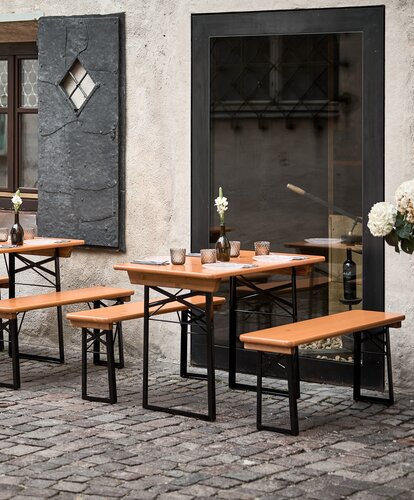 Several small beer garden table sets were placed in an outdoor area.