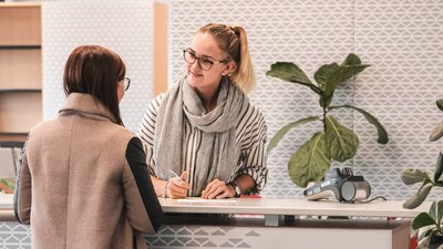 The photo shows a staff member providing information and advice to a customer.