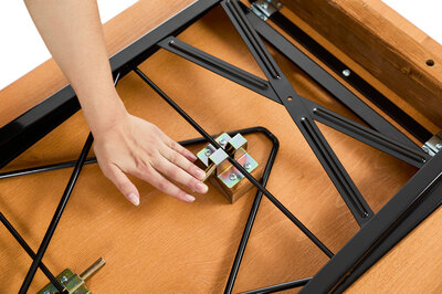 One hand pushes down the lever of the folding furniture lock to assemble the Shorty.