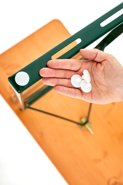 The attached plastic sliders to a base. One hand holds three more plastic sliders into the picture.