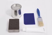 Das Reparaturset besteht aus Lasur, Holzkitt, Spachtel, Pinsel, Schleifpapier und Anleitung.