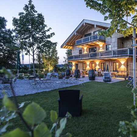 Die Biergartenmöbel stehen vor einem Hotel auf der Terrasse.