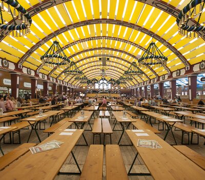 Auf dem Foto sieht man viele Comfort Bierzeltgarnituren mit Beinfreiheit in einem Oktoberfest-Festzelt.